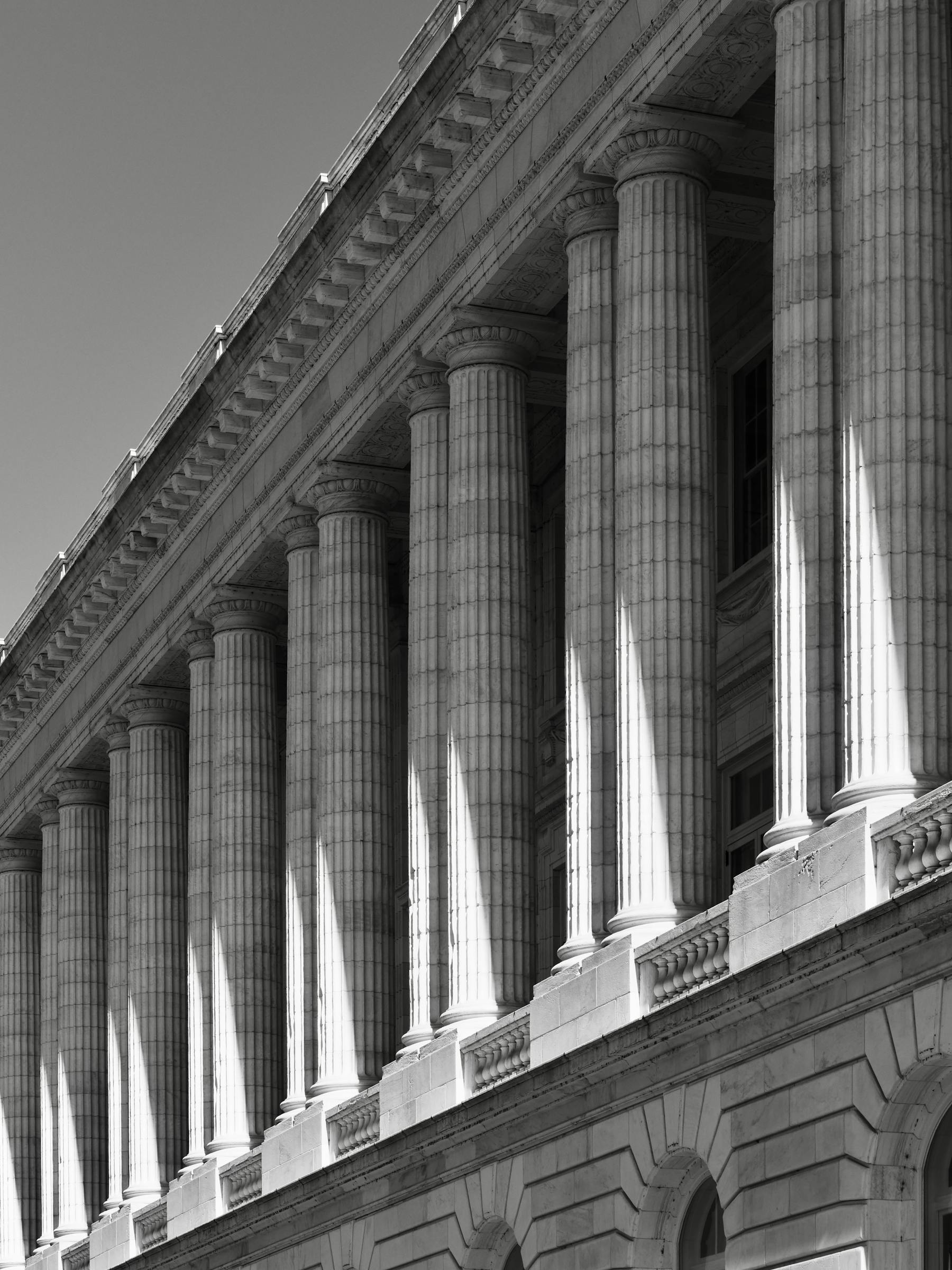 Neoclassical stone columns on an institutional building, photographed at a dramatic angle